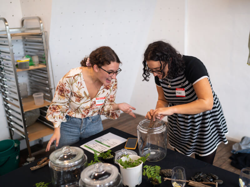 Two female colleagues building a terrarium at a terrarium class for team building